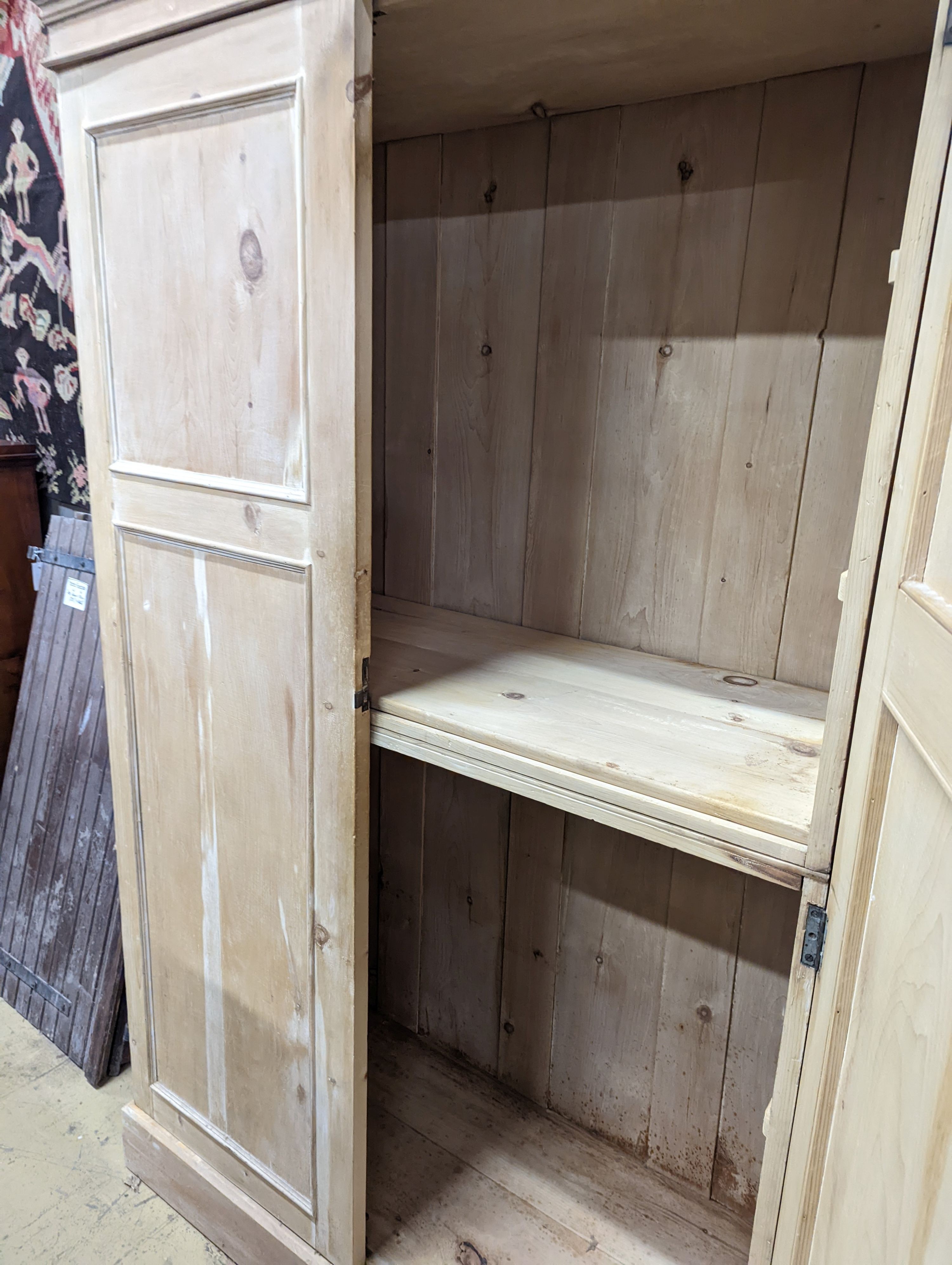 An early 20th century stripped pine two door press cupboard, width 120cm, depth 52cm